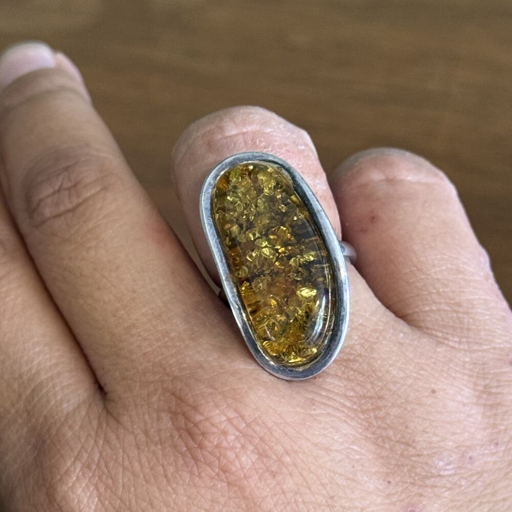 A Baltic amber statement ring set in a simple sterling silver bezel band 7.5